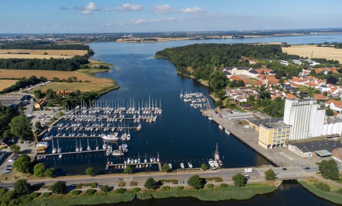 Augustenborgs lystbådehavn ved bunden af Augustenborg Fjord. Den gule bygning ned til havnen er DLG's silo. I baggrunden til højre ses Augustenborg Slot. Foto fra 2022. Augustenborgs lystbådehavn ved bunden af Augustenborg Fjord. Den gule bygning ned til havnen er DLG's silo. I baggrunden til højre ses Augustenborg Slot. Foto fra 2022.