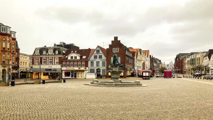 Den store markedsplads i Husum. Midt på pladsen står springvandet "Tine" fra 1905, der viser en ung fiskerkone i træsko. Foto fra 2022. Den store markedsplads i Husum. Midt på pladsen står springvandet "Tine" fra 1905, der viser en ung fiskerkone i træsko. Foto fra 2022.