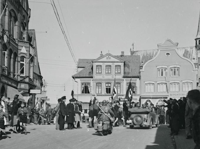 Hjemmetyskere modtager de tyske soldater med faner og nazihilsen på torvet i Haderslev den 9. april 1940. Hjemmetyskere modtager de tyske soldater med faner og nazihilsen på torvet i Haderslev den 9. april 1940.