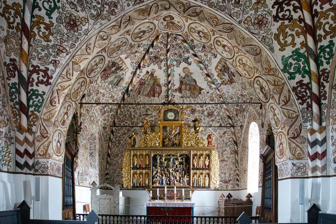 Koret i Møgeltønder Kirke med altertavle fra ca. år 1500 og lofte og vægge dækket af kalkmalerier fra 1500-tallet. Koret i Møgeltønder Kirke med altertavle fra ca. år 1500 og lofte og vægge dækket af kalkmalerier fra 1500-tallet.
